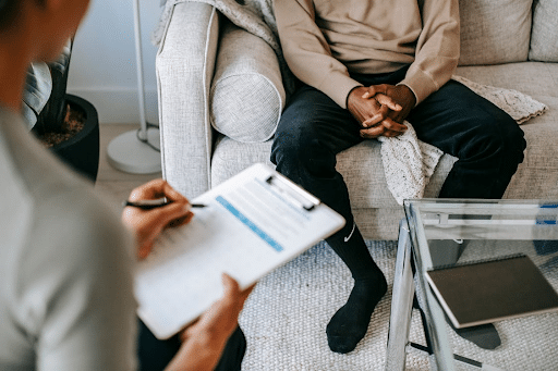 Analyse transactionnelle en coaching professionnel Analyse transactionnelle en coaching professionnel avec une personne prenant des notes pendant qu’un homme est assis sur un canapé.